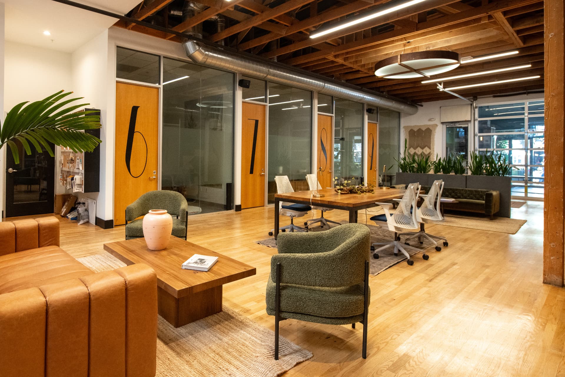 Private office suites and lounge at Kiva State St. with leather seating and a wooden conference table